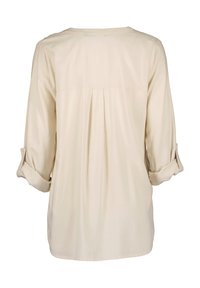 Blusa beige a maniche lunghe con maniche arrotolate, collo rotondo e dettaglio di piega sul retro. Tessuto liscio, vestibilità casual e materiale leggero.