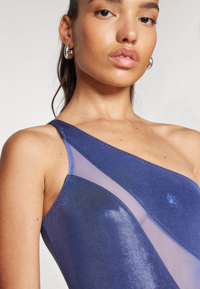 Maillot de bain asymétrique bleu marine avec un panneau en mesh transparent, une texture de tissu brillante et un design épuré et moderne avec un minimum de couture.