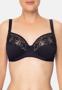 Reggiseno nero con dettagli in pizzo e coppe in rete, caratterizzato da bordi ondulati, spalline regolabili e un accento centrale a fiocco.