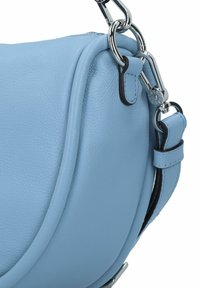 Borsa in pelle blu chiaro dalla forma arrotondata, con accessori in argento, tracolla staccabile e dettagli superficiali leggermente testurizzati.