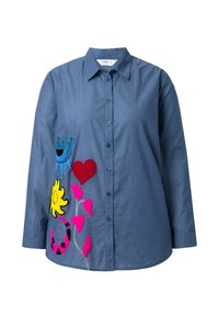 Camicia azzurra con bottoni e maniche lunghe, decorata con ricami multicolori di una corona, un cuore, un sole e fiori sul lato sinistro.