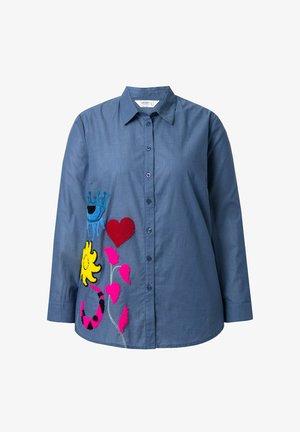 Niebieska koszula z długim rękawem z wielokolorowym haftem przedstawiającym koronę, serce, słońce i kwiaty po lewej stronie.