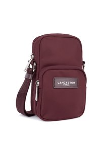 Borsa a tracolla compatta color bordeaux con due scomparti con zip e una tracolla regolabile, caratterizzata dal logo "Lancaster Paris" sul fronte.