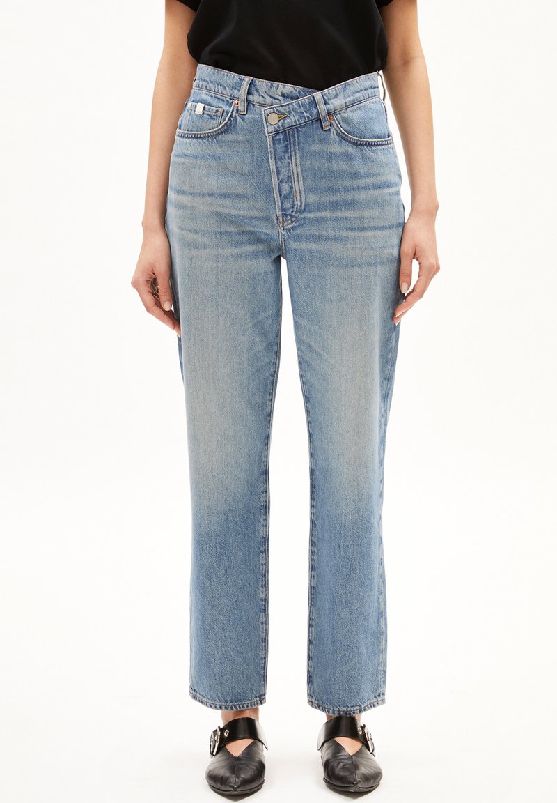 Jeans de mezclilla azul claro con cintura alta, corte recto, diseño de cinco bolsillos y un lavado ligeramente desgastado. Terminados con un dobladillo sin terminar.