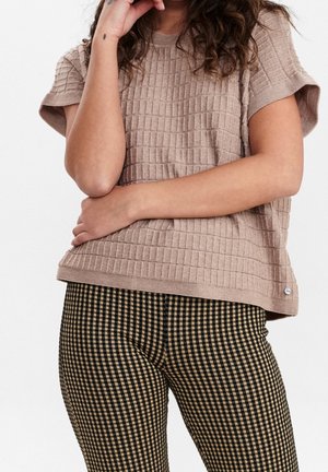 Beige gebreide trui met een geruit patroon, korte mouwen, gecombineerd met zwart-beige geruite legging, met een aansluitende pasvorm en een lichte glans.