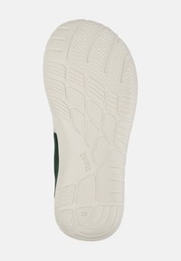 Semelle d'une basket verte montrant un caoutchouc blanc texturé avec divers motifs, étiquetée "CAMPER" et un numéro de taille "28."