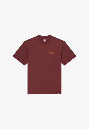 Mørkerød bomulds t-shirt med korte ærmer, rund hals og lille orange "DICKIES" logo på brystet. Glat tekstur, afslappet design.