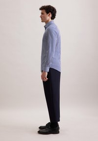 Gestreepte blauwe overhemd met kraag, gecombineerd met donkere, op maat gemaakte broeken en zwarte geklede schoenen. Heeft een slim fit en lange mouwen.