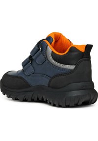 Calzature blu navy con suola in gomma nera, interno arancione, due cinturini in velcro e collo imbottito. Presenta una parte superiore testurizzata per maggiore durabilità.