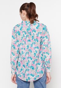 Bloemige blouse met knopen, voorzien van een lichtgrijze basis en turquoise en roze bloempatronen, lange mouwen en een gebogen zoom.