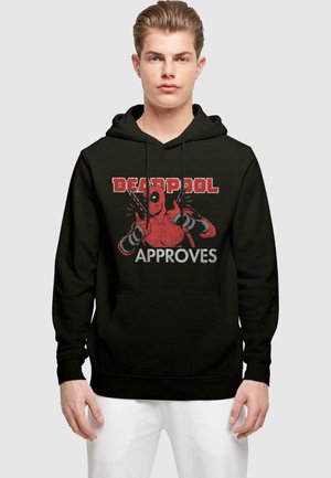 Svart hettegenser med et grafisk trykk av den røde Deadpool-karakteren med hevede hender og ordet "GODKJENT" i hvit tekst. Mykt, bomullsmateriale.