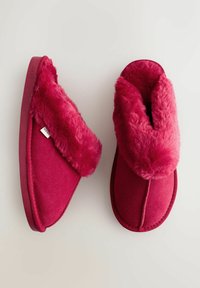 Piros műszőrme-bélésű papucsok puha velúr külsővel, lekerekített orral, puha szegéllyel és texturált gumitalppal.