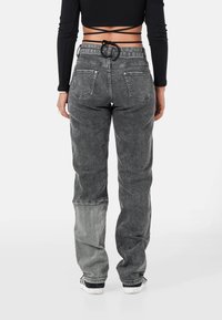 Pantalones cargo de mezclilla negros de talle alto con un aspecto desgastado, que presentan un diseño de color dividido único y una cintura con cordón.