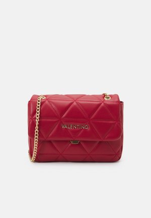 Rode doorgestikte leren Valentino handtas met gouden kettingriem en gouden logo aan de voorkant, tegen een effen lichte achtergrond.