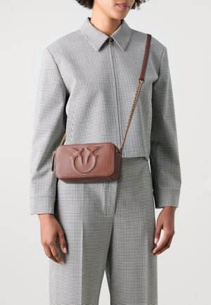 Borsa a tracolla in pelle marrone con logo impresso, tracolla in catena dorata, forma rettangolare, cuciture a contrasto e finitura testurizzata.