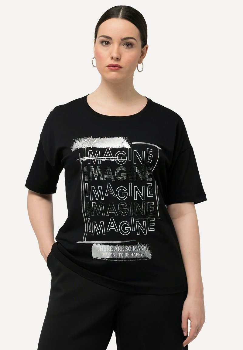 Camiseta de algodón negra de manga corta que presenta gráficos de texto blancos que dicen "IMAGINA" y "HAY TANTAS RAZONES PARA SER FELIZ."