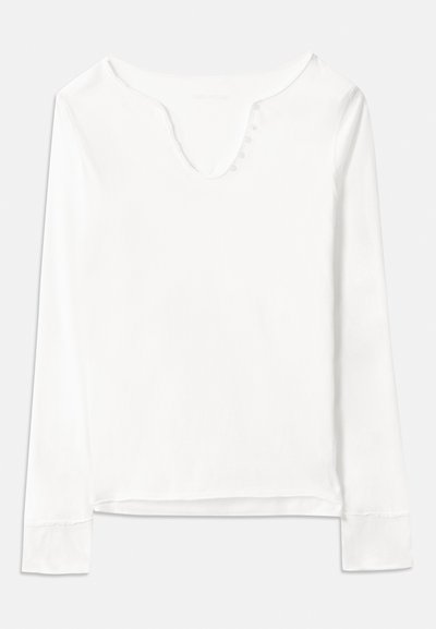 Balta ilga rankovė palaidinė su V formos kaklu, puošta penkiomis mažomis sagutėmis priekyje, pagaminta iš lengvo audinio su lygiu paviršiumi.