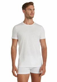 White cotton t-shirt with short sleeves and a crew neckline, paired with white fitted shorts. Smooth texture, slim fit design.