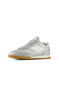 Chaussure de sport argentée avec une tige en cuir texturé, un logo blanc et une semelle en caoutchouc naturel. Dotée de lacets plats et d'un design profilé bas.