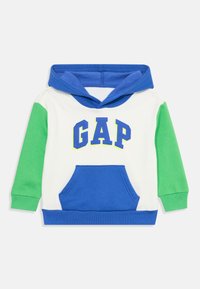Sweatshirt à capuche avec un corps bleu, des manches vertes et un devant blanc. Il dispose d'une poche à l'avant et d'un logo "GAP" imprimé en bleu et jaune.