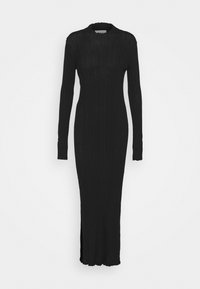 Robe noire côtelée à manches longues avec un col montant et des fentes latérales. Le tissu est texturé et ajusté, créant une silhouette épurée.