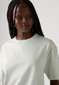 Lys grøn oversized t-shirt lavet af blødt stof, med rund halsudskæring og korte ærmer. Glat tekstur og afslappet pasform.
