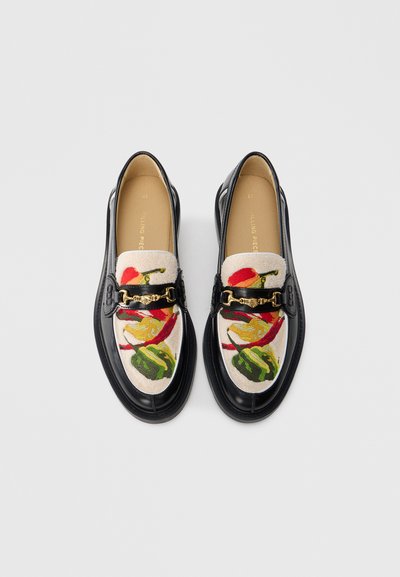 Μαύρες δερμάτινες μοκασίνες με υφασμάτινο πάνω μέρος σε υφή και πολύχρωμο λουλουδένιο σχέδιο, διακοσμημένες με αλυσίδα στην περιοχή του πελματικού τόξου.