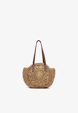 Sac à main rond en paille tissée avec des bandoulières en cuir marron, avec un motif circulaire et un design à tissage ouvert.