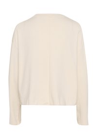 Chemise à manches longues couleur crème avec une coupe décontractée, un ourlet droit et une couture verticale visible au centre du dos.