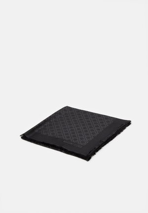 Cachecol preto com um padrão geométrico tonal, bordas com franjas e uma etiqueta de logótipo. Feito de um tecido macio, tem forma quadrada.