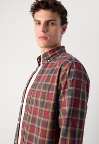 Geruite shirt in rood, marineblauw en geel; met kraag, knoopsluiting en borstzak; van katoenmix stof; heeft een gestructureerde pasvorm en zachte textuur.
