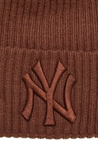 Berretto a maglia marrone caratterizzato da un logo NY ricamato in evidenza. Il tessuto presenta una texture a coste, che aggiunge profondità e interesse.