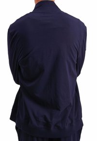 Giacca zip-up blu navy realizzata in tessuto morbido, con collo a costine e polsini elasticizzati, che presenta una texture liscia e una vestibilità rilassata.