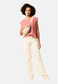 Vaaleanpunainen lyhythihainen paita, kermaisen väriset leveälahkeiset housut, beige olkalaukku, jossa on tekstuuroitu pinta ja säädettävä hihna, sekä vaaleat tennarit.