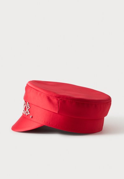 Casquette rouge à dessus plat avec une courte visière et des ornements décoratifs en strass sur le côté avant gauche.