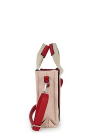Beige fabric handbag with red leather handles and detachable shoulder strap, shown from side on white background.