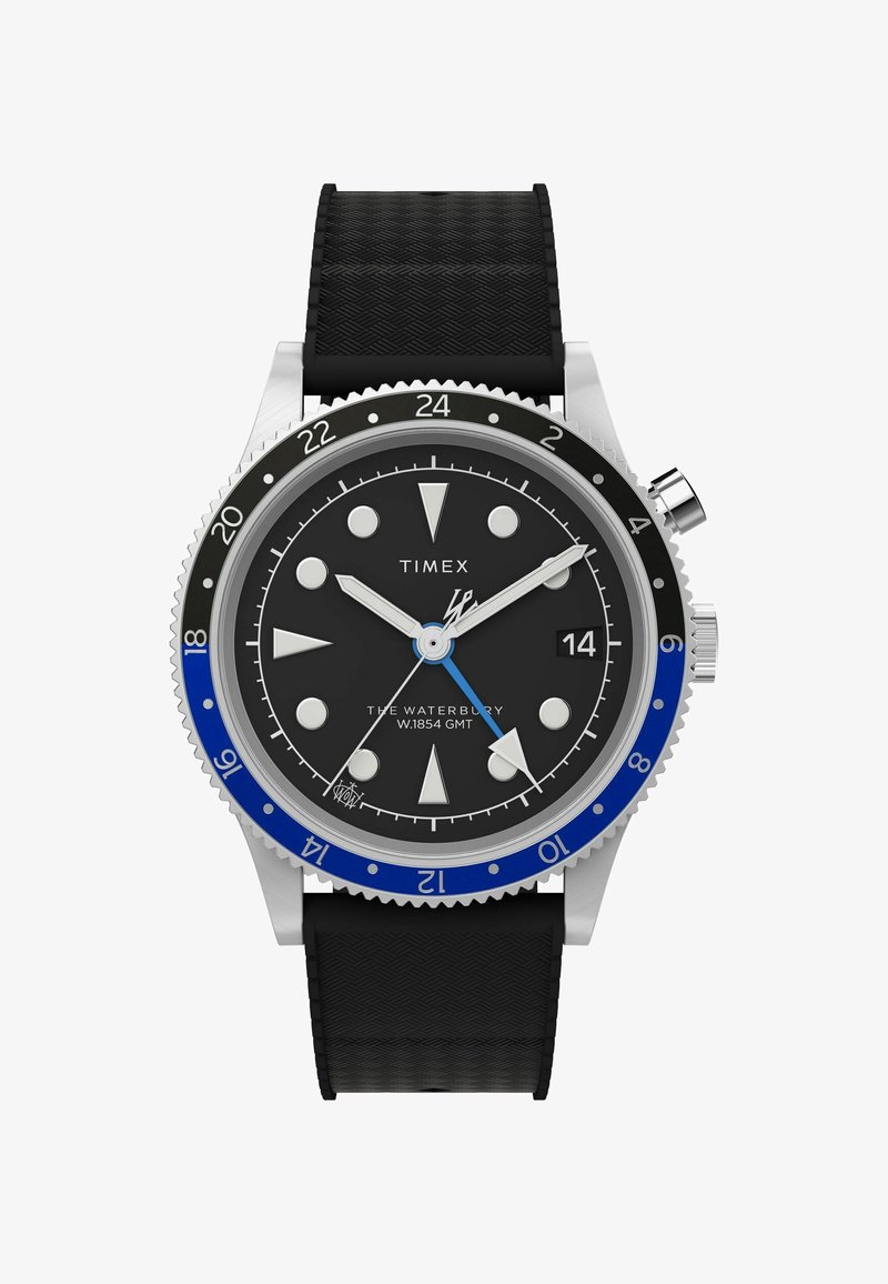 Zegarek Timex Waterbury GMT z czarną tarczą, srebrną stalową kopertą, niebiesko-czarnym pierścieniem oraz teksturowanym czarnym paskiem z gumy.