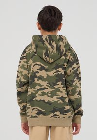 Zielona bluza z kamuflażem, z kapturem ze sznurkiem, długimi rękawami i ściągaczami. Wykonana z miękkiego, teksturowanego materiału.