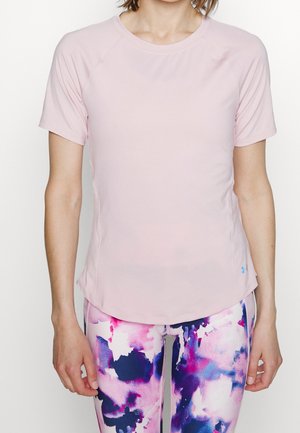 Helles rosa Sport-T-Shirt mit kurzen Raglanärmeln, glatter Textur, leicht geschwungenem Saum und kombiniert mit bunten, gemusterten Leggings.