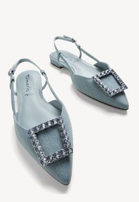 Tacchi slingback in denim azzurro chiaro con punta affusolata, caratterizzati da una grande fibbia in strass sul davanti e un tacco a blocco basso.
