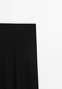 Jupe noire taille haute, coupe droite et tissu lisse sur fond blanc.