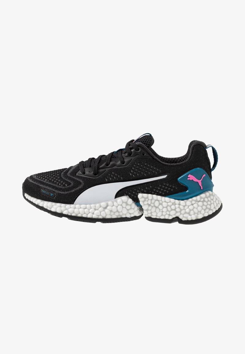 Baskets de course Puma en noir et blanc avec une semelle en mousse texturée, un accent de talon bleu, un logo Puma rose et des lacets noirs.