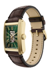 Rechthoekig groen horloge met gouden accenten, Romeinse cijfers en een doorzichtig achterdeksel, op een donkerbruin leren band met een beige voering.