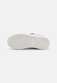 Shoe with a textured white rubber sole, featuring a honeycomb pattern for traction. The upper is colorful with purple and green accents.