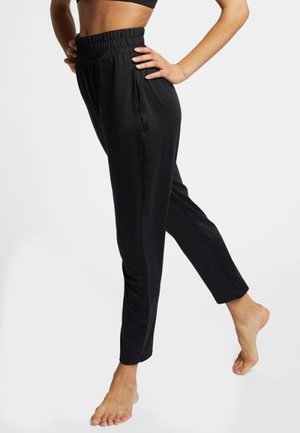 Černé lehké teplákové kalhoty s elastickým pasem, zužujícím se střihem nohavic a bočními kapsami. Hladká textura s přiléhavým střihem.