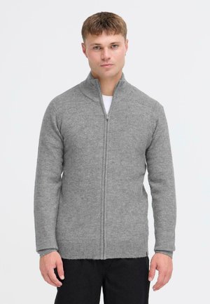 Gray zip-up sweater made of soft, textured fabric with a high collar and ribbed cuffs. Features a straight-cut design and front zipper.