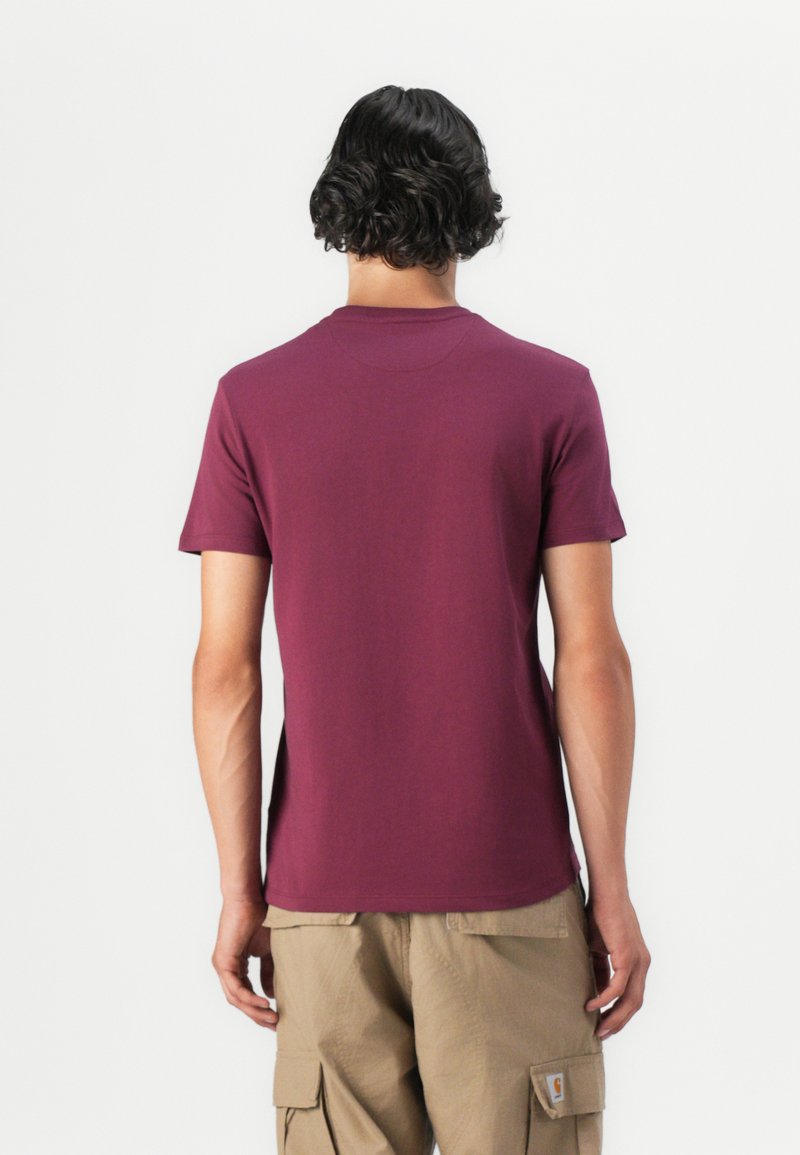 T-shirt in cotone bordeaux con maniche corte e scollo rotondo, mostrato da dietro; texture liscia e design semplice senza decorazioni.