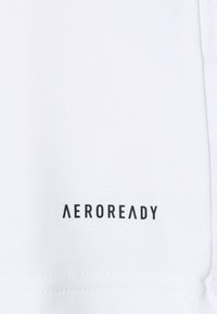 Witte stof met een gladde textuur en een zichtbaar zwart "AEROREADY" logo in een modern lettertype, gepositioneerd aan de onderkant.