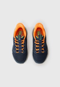 Baskets pour enfants Skechers slip résistantes, bleu marine et orange avec des accents verts, en tissu en maille, et languettes de tirage, vues de dessus sur fond blanc.