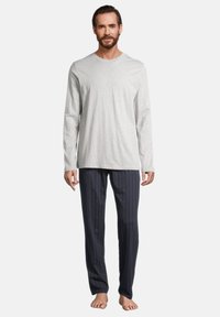 Chemise gris à manches longues assortie à un pantalon rayé bleu marine, en tissu doux, avec une coupe décontractée et un col classique. Aucun motif visible.